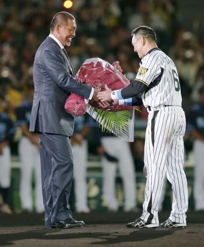 引退セレモニーで、阪神・金本知憲外野手に花束を手渡す元オリックス選手の清原和博氏（左）