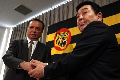 中村ＧＭ（左）と握手をかわす阪神・黒田ヘッドコーチ（右）
