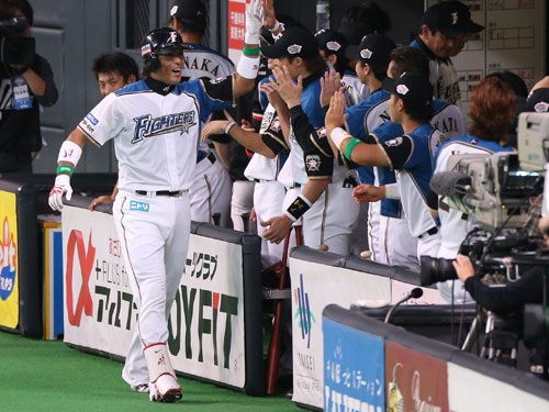 ＜日本ハム・巨人＞２回１死、右中間にソロ本塁打を放ち、ベンチの祝福を受ける稲葉（左）