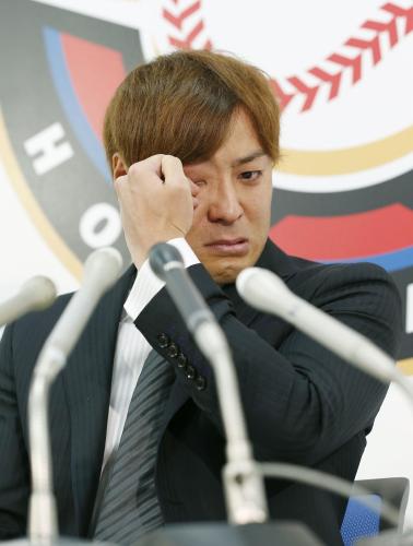 米大リーグ挑戦を表明した記者会見で、涙を拭う日本ハムの田中賢介内野手