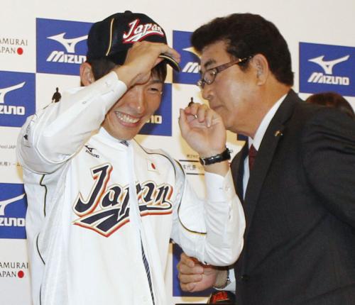 日本代表のユニホームを着用し笑顔を見せるソフトバンク・本多（左）。右は山本監督