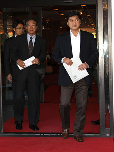 交渉を終えてホテルを出る日本ハム・山田ＧＭ（左）と父・大谷徹さん