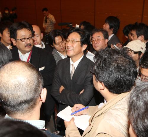 日本ハム・栗山監督（中央）は報道陣に囲まれ、交渉の手応えを聞かれて笑顔を見せる