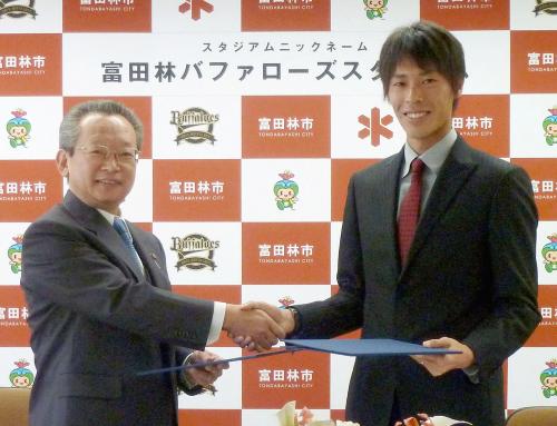 「スタジアムニックネーム」協定を締結し、握手するオリックス・前田祐二投手（右）と多田利喜・富田林市長