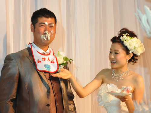 顔にウエディングケーキを付け幸せいっぱいの広島・大竹。右は杏里夫人