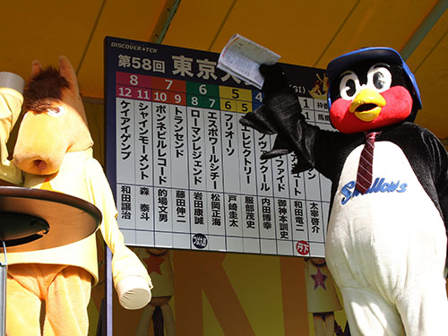 集まったファンに手を振るつば九郎（右）と東京シティ競馬のマスコット・うまたせ！