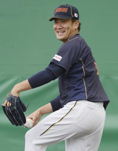 ブルペンで投球練習中に笑顔を見せる田中