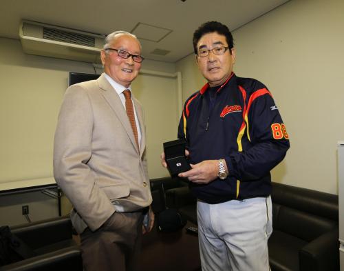 試合前に侍ジャパンの山本監督（右）にピンバッジを手渡し、激励した巨人・長嶋終身名誉監督