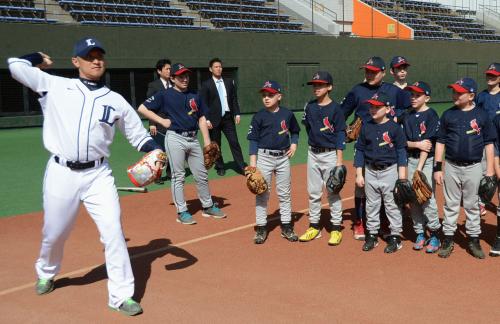モスクワの少年野球チームに投球動作を指導する平尾博嗣氏（左）