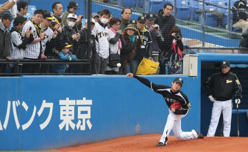 ＜ヤ・神＞大勢のファンと和田監督（右）が見守る中、ブルペンで投球練習をする阪神・藤浪