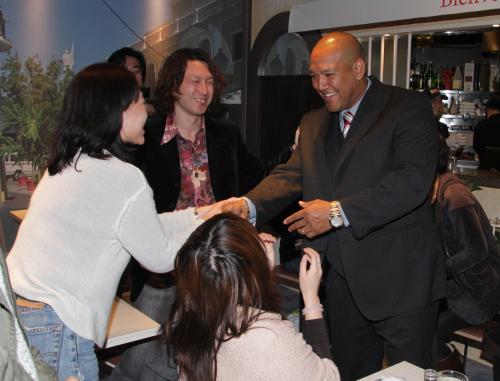 ラミちゃんカフェの来店客と握手するラミレス