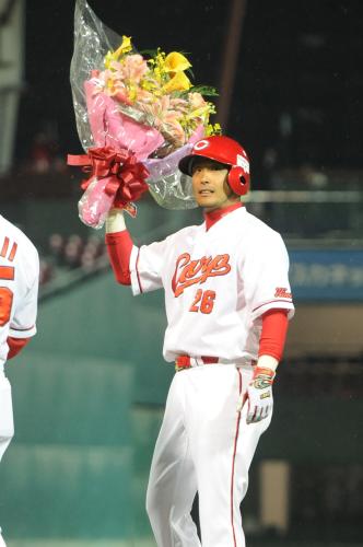 広瀬はプロ野球新記録の１５打席連続出塁を達成し花束を掲げる