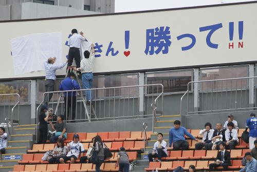 試合前に「キヨシさん！　勝って！！」と書かれた広告看板を白い布で隠す横浜スタジアム関係者