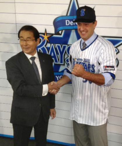 ＤｅＮＡの入団会見後、握手を交わす高田繁ＧＭ（左）とコーコラン投手