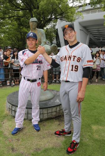オールスターの監督推薦を受け、沢村栄治像の前で握手を交わすヤクルト・小川（左）と巨人・菅野