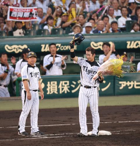 ＜神・巨＞２回、西岡（手前右）は中前打を放ち日本通算１０００本安打を達成。花束を手に観衆にあいさつ