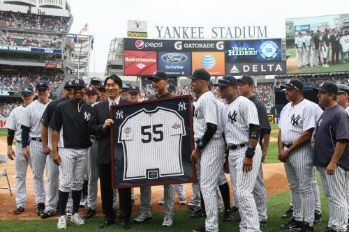 引退セレモニーでヤンキースの選手と記念撮影に臨むスーツ姿の松井氏