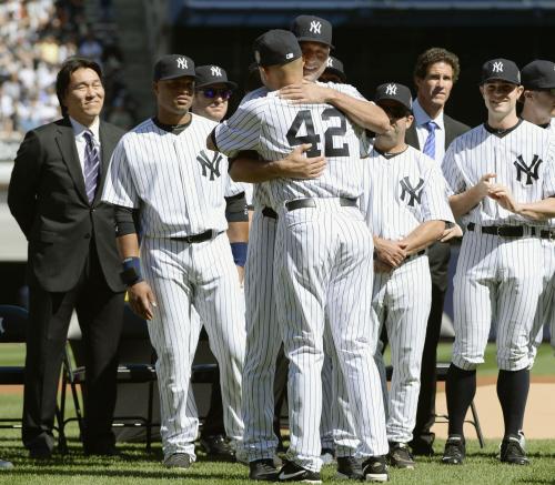 試合前の引退式典で、ヤンキースのリベラ（42）を抱いて祝福するジーター（中央奥）。左端は松井秀喜氏