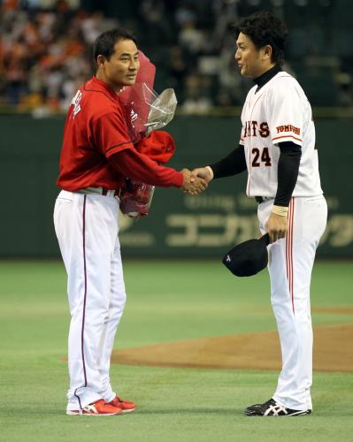 ＜巨・広＞試合前、前田智（左）は、巨人・高橋に花束を手渡され握手