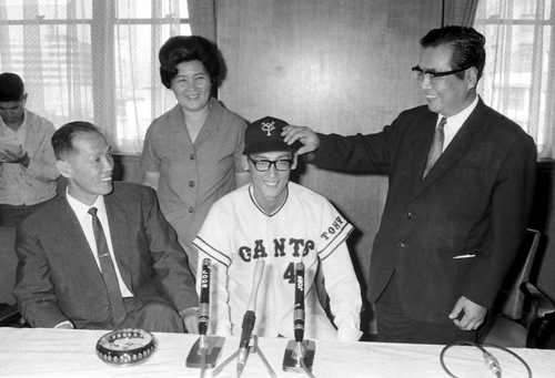 １９６８年９月９日、巨人入団発表で巨人の正力亨オーナー（右）から巨人の帽子をかぶらせてもらう新浦寿夫（右から２人目）