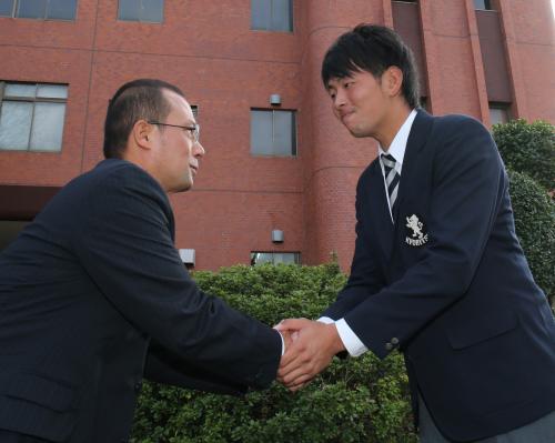 田村スカウト（左）と固く握手をかわす大瀬良