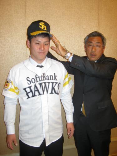 宮田スカウト部長補佐から帽子を添えられるソフトバンクのドラフト３位・岡本