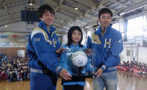 滝川第二小学校を訪れ、児童代表に記念品を贈呈する日本ハム・斎藤（右）と乾