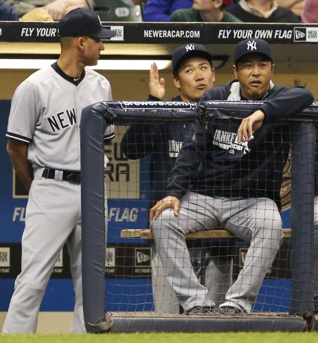 ＜ブルワーズ・ヤンキース＞ベンチでジーター（左）と話すヤンキース・田中。右は黒田