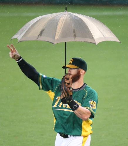 ＜神・Ｄ＞雨天のため試合開始が遅れ待ちくたびれるファンを盛り上げるため、傘をさしてエアキャッチボールをするマートン
