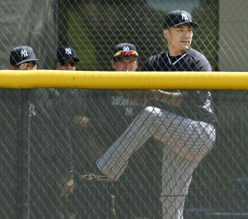 マイナー施設のブルペンで、スタッフに見守られ投球練習をする田中