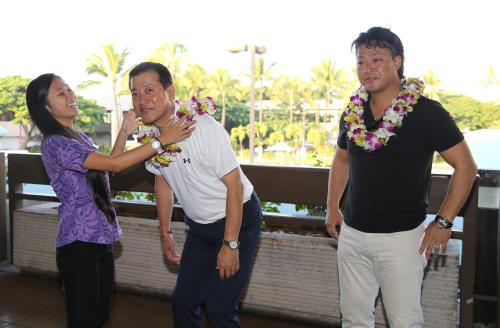 ハワイに到着した原監督（左）と村田は現地の係員にレイをかけられる