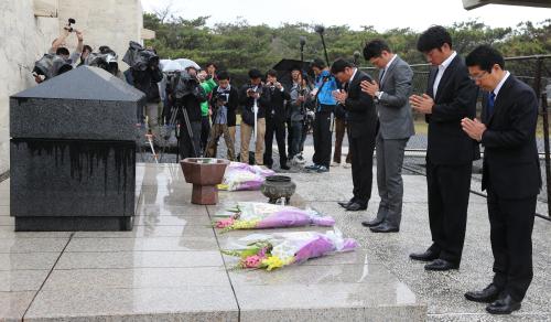 平和祈念公園を訪れ献花する（手前から）原沢球団代表、相川、坂本、金城
