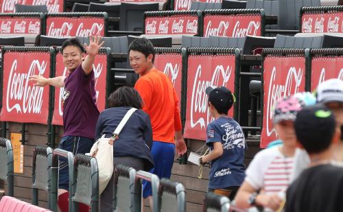 コボスタ宮城の中を歩いている途中にスタジアム見学の小学生に手を振る松井裕。右は福田