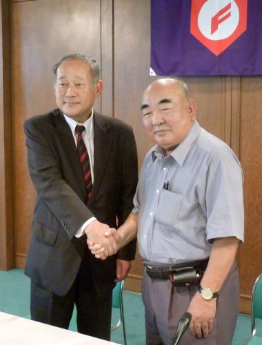 日本高野連の新会長に就任し、奥島孝康前会長（右）と握手を交わす八田英二氏