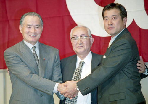 ０１年９月、長嶋監督（左）の辞任記者会見で握手する原ヘッドコーチ（右）。中央は渡辺オーナー