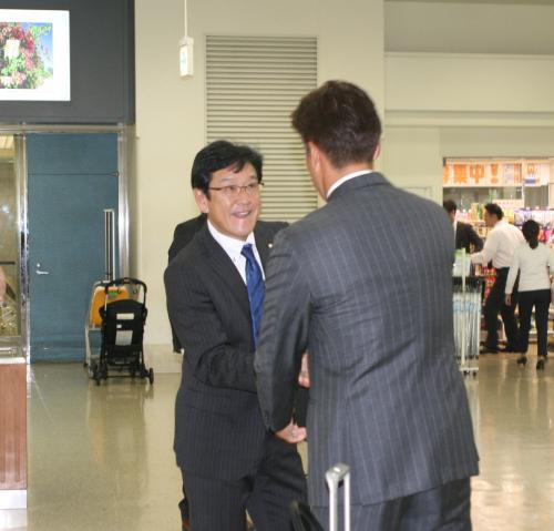 沖縄入りした日本ハム・栗山監督。那覇空港に先に到着していた高橋新コーチを発見するとガッチリ握手