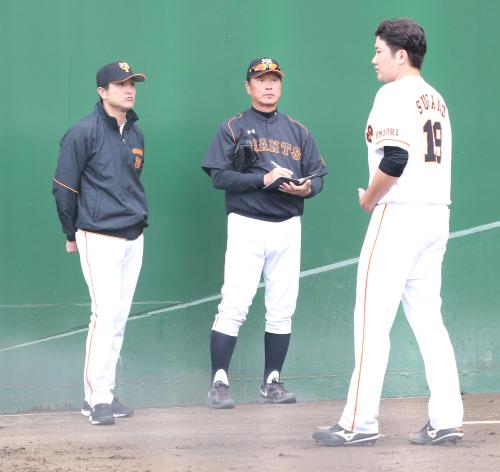 ブルペンで菅野（右）と話をする高橋監督（左）、尾花投手コーチ