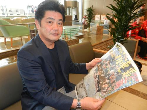 日本一から一夜明け、歓喜の瞬間を伝えるスポニチ本紙を手にするソフトバンク・工藤監督