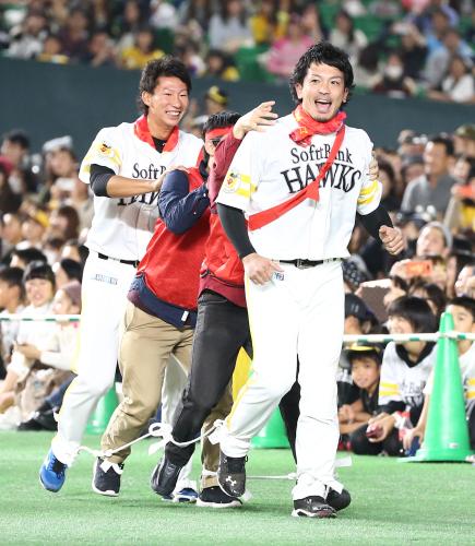 ファンとムカデ競走し笑顔を見せる松田。左は真砂