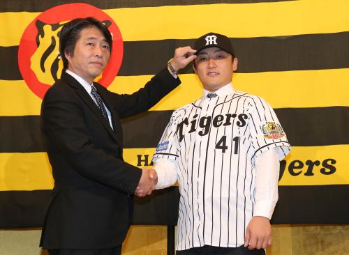 阪神に入団した高橋は高野球団本部長（左）と笑顔で握手