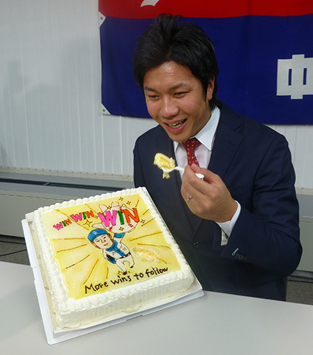 １億円の大台突破記念で報道陣から贈られたケーキをほおばる中日・大野