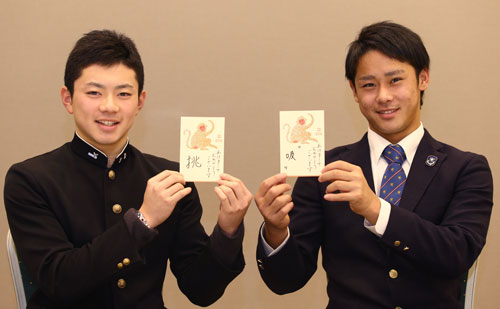 今年の目標とする１字を記した年賀状を手に活躍を誓う平沢（右）と成田
