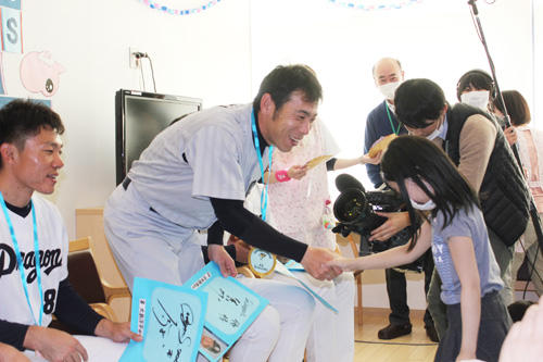 名古屋第一赤十字病院を慰問し、小児病棟で治療中の女児から歓迎を受け、笑顔の荒木（中央）と大島（左）