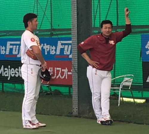 午後にもブルペンに入った安楽（左）は与田投手コーチからアドバイスを送られる