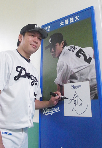 ナゴヤドームに設置された自身の写真パネルにサインする中日・大野選手会長