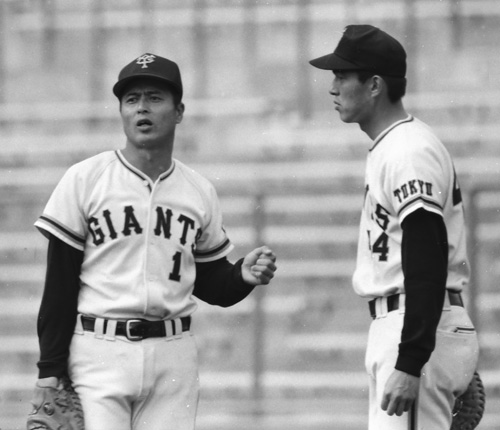 １９７６年、一塁守備で王（左）の助言を受ける山本功児
