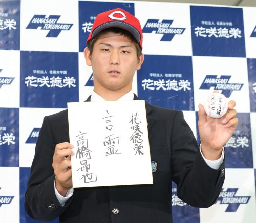 広島に２位で指名された高橋昴也投手は帽子をかぶり座右の銘が書かれた色紙と目標が書かれたボールを手に笑顔でポーズ
