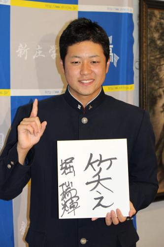 座右の銘「笑え」の色紙を手に、笑顔を見せる広島新庄・堀