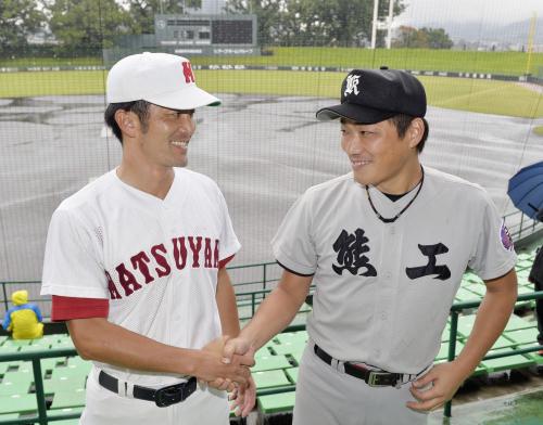 試合が雨天中止となり、再戦を誓い握手する松山商ＯＢの矢野さん（左）と熊本工ＯＢの星子さん