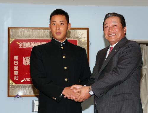横浜高の玄関で梨田監督（左）を出迎え握手する藤平